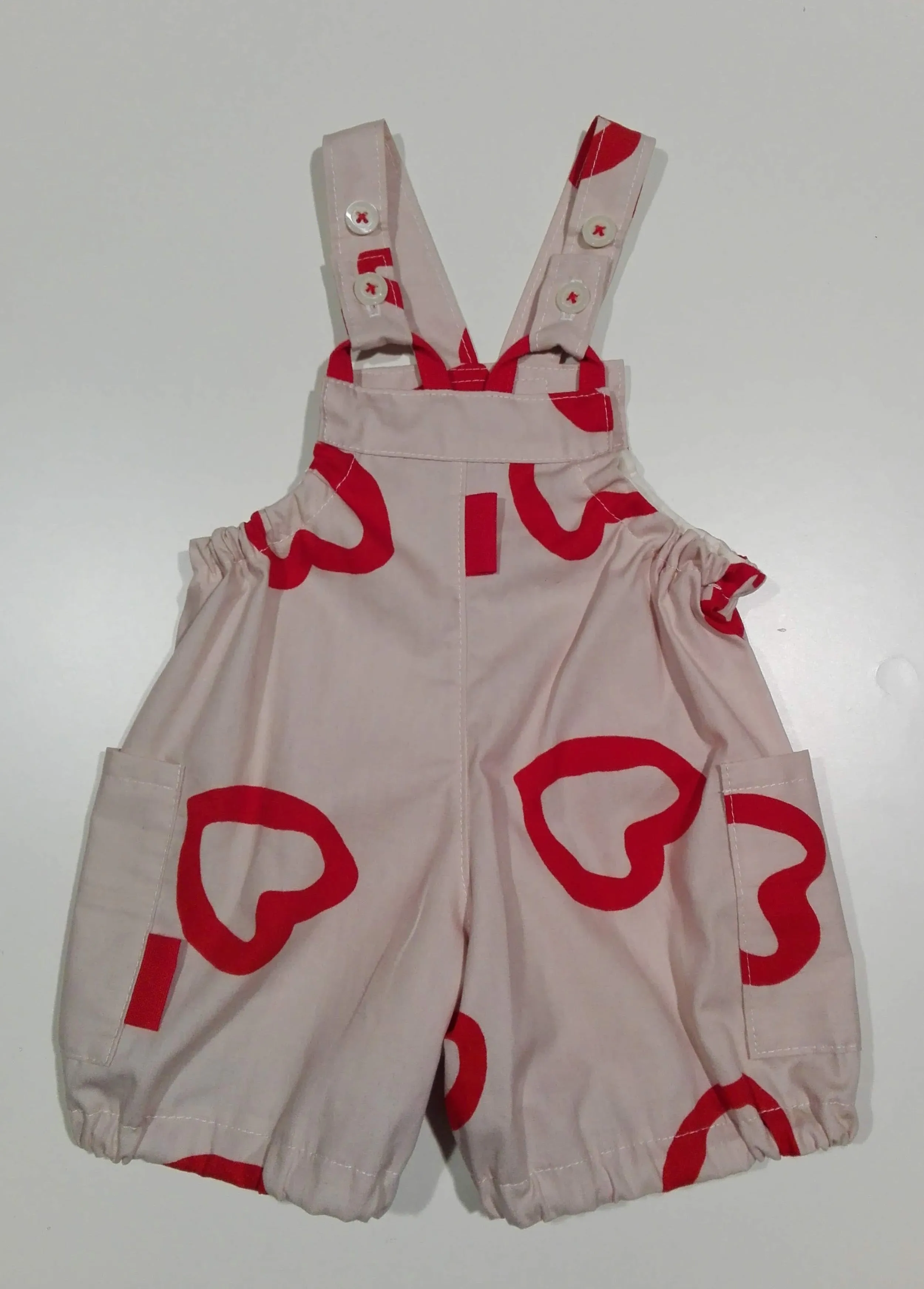 Romper in cotton red hearts.